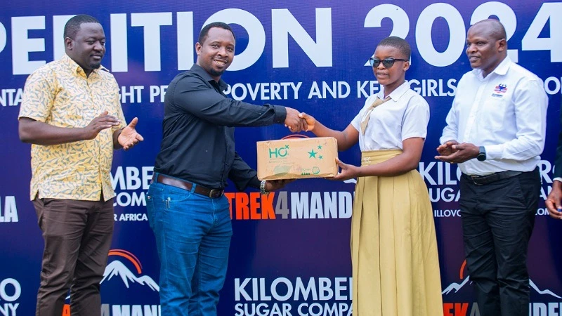 Moshi District Commissioner Hon. Zephania Stephen Sumaye hands over sanitary pads to a student of Mieresini Secondary School located in Kilimanjaro region during a hand over ceremony in Moshi yesterday.  