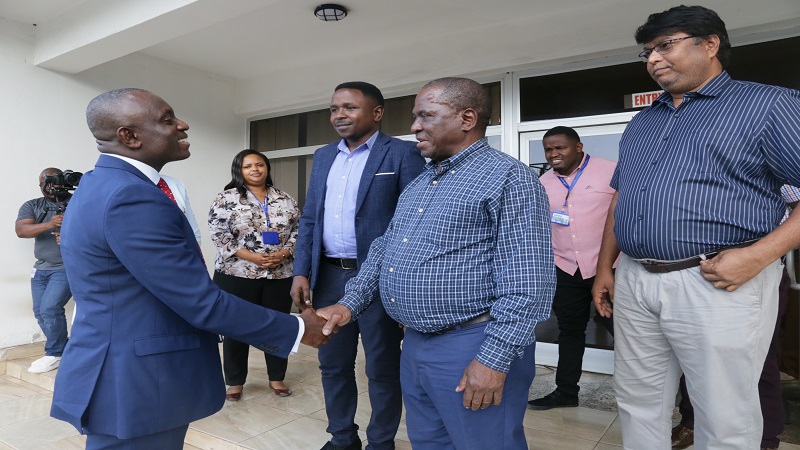 The Guardian newspaper managing editor Wallace Mauggo exchanges greetings with Dr Asiedu at the TGL offices. 