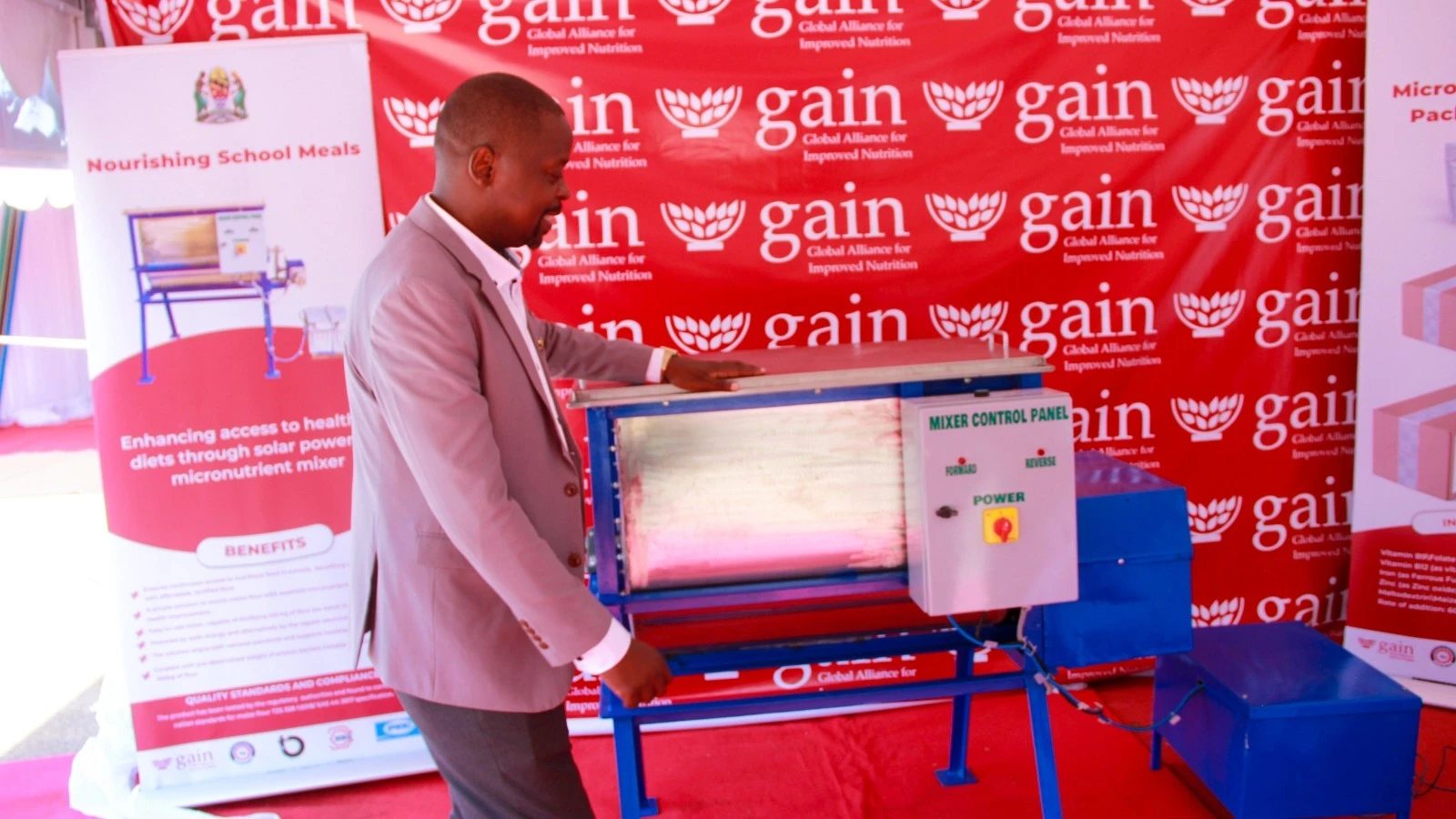 Project Manager of Food Fortification Program, GAIN TZ, Archard Ngemela showing the fortification machine. 