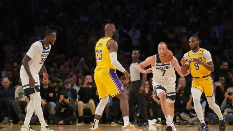 Los Angeles Lakers forward LeBron James (23) passes to guard Bronny James (9) during the first half of an NBA basketball game against the Minnesota Timberwolves, Tuesday, Oct. 22, 2024, in Los Angeles.