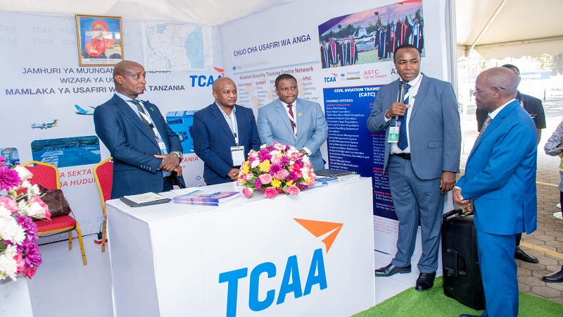 Tanzania Civil Aviation Authority director general Salim Msangi (2nd-R) briefs Transport minister Prof Makame Mbarawa (R) on Thursday at the TCAA pavilion at the 17th Transport Sector Stakeholders’ Meeting on Monitoring and Evaluation held in Arusha city.