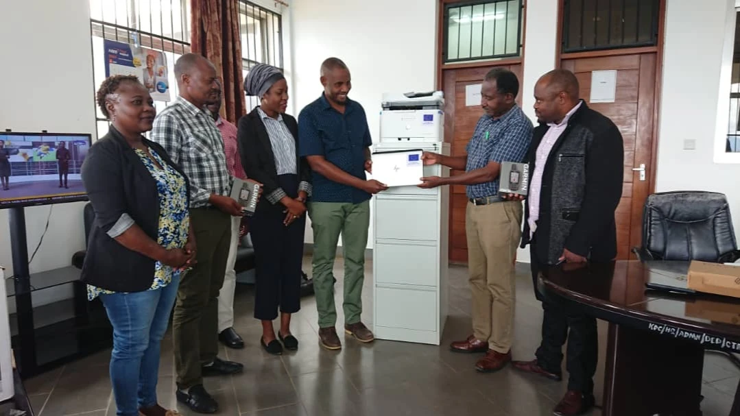 Simon Lugazo,IFBEST’s project manager (4th L)hands  over the Laptop and office cabinet to Mng’anya Chrispin,Kilindi District Council, head of planning and coordination (2nd R) with the support from IFBEST project.Others are staff from TFCG and MJUMITA.