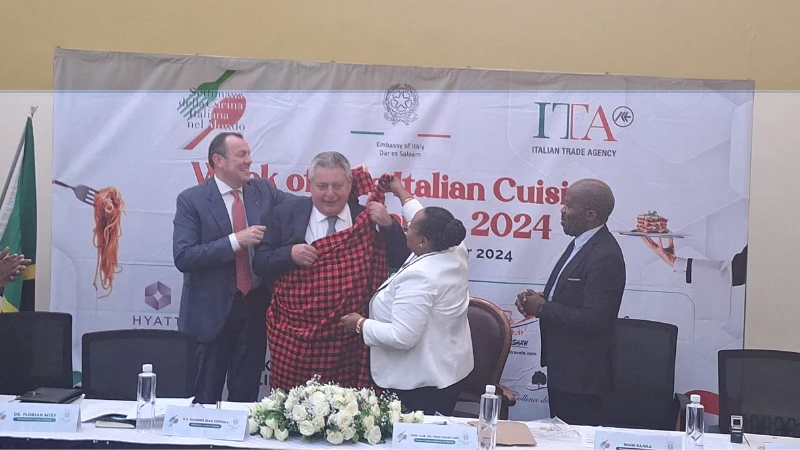 The Minister of Natural Resources and Tourism, Pindi Chana, presented a Maasai attire to Antonino Zigilo, President of the College of Italian Studies (ENAIP), during the signing of a cooperation agreement with the National College of Tourism (NCT) in Dar.