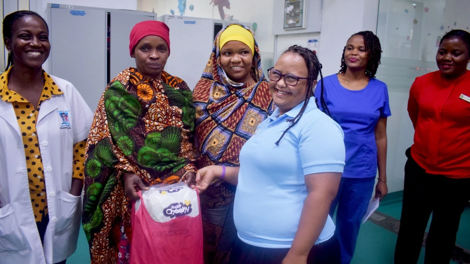 Penny Pettit, a physically challenged young woman hands over gifts to children with down syndrome condition at the Jakaya Kikwete Cardiac Institute (JKCI) in Dar es Salaam recently.