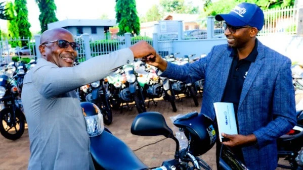 Dr Frederick Ndossi (Right), Tanzania Health Promotion Support (THPS) Afya Hatua Project Care and Treatment Director symbolically presents 40 motorcycles worth a total of about 141.4 m/- to Kigoma Regional Commissioner, Thobias Andengenye (Left).