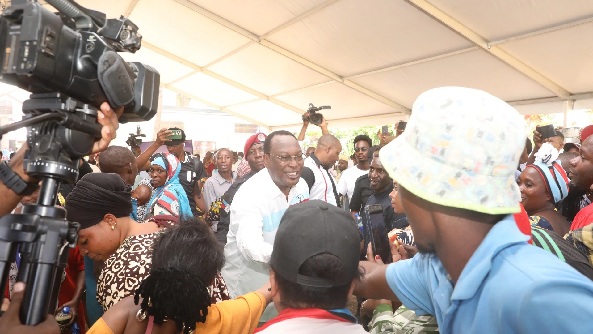 A visibly ecstatic opposition Chadema national Chairman Freeman Mbowe (C, in glasses) exchanges greetings with presumed members of the party who flocked to his Dar es Salaam residence yesterday, 