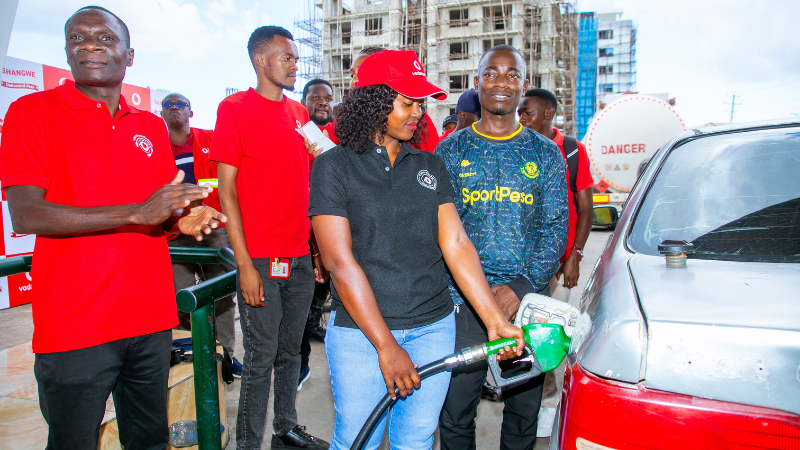 VodaBima officer Hellen Masali fuels Zacharia Regan's car in Mwanza during Vodacom's 'Ni Balaa! Everyone is a Winner' campaign, aimed at spreading holiday cheer to customers nationwide.