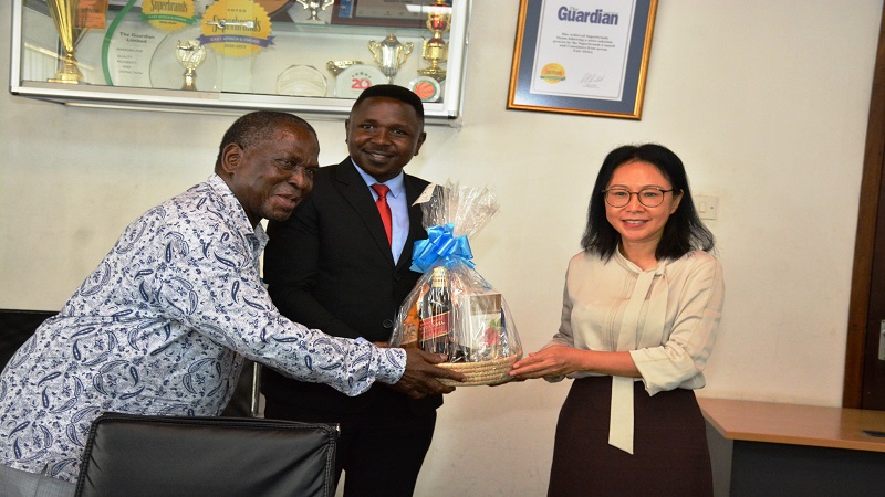 TGL Deputy General Manager Jackson Paulo (C) and The Guardian Newspaper Managing Editor Wallace Mauggo receive the New Year gift from Ambassador Chen. 