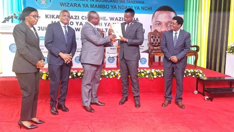 Home Affairs Minister, Innocent Bashungwa (2nd R), hands over the Ministry's communication strategy to Tanzania Editors' Forum chairperson, Deodatus Balile, during a meeting between the Minister and members of the Forum in Dar es Salaam yesterday. 