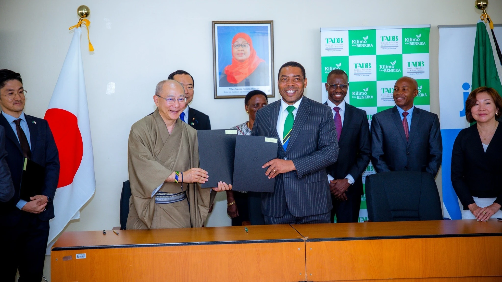 Finance Minister Dr Mwigulu Nchemba (C) and the outgoing Japanese ambassador to Tanzania, Yasushi Misawa (L) exchanging agreements for projects to be financed by the Japan International Cooperation Agency (JICA) in Dar es Salaam yesterday