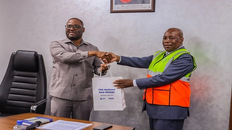 Dar es Salaam Port Acting Director Abed Gallus (L), presents a gift to the Chairman of the Tanzania Business Community, Hamis Livembe, during their visit at Dar es Salaam Port on Wednesday to observe the investments made at the port. 