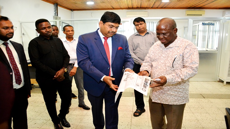 The Guardian newspaper Managing Editor Wallace Mauggo (R), shows to the High Commissioner Bishwadip Dey a copy of an edition of The Guardian newspaper during his visit to TGL's newsroom.