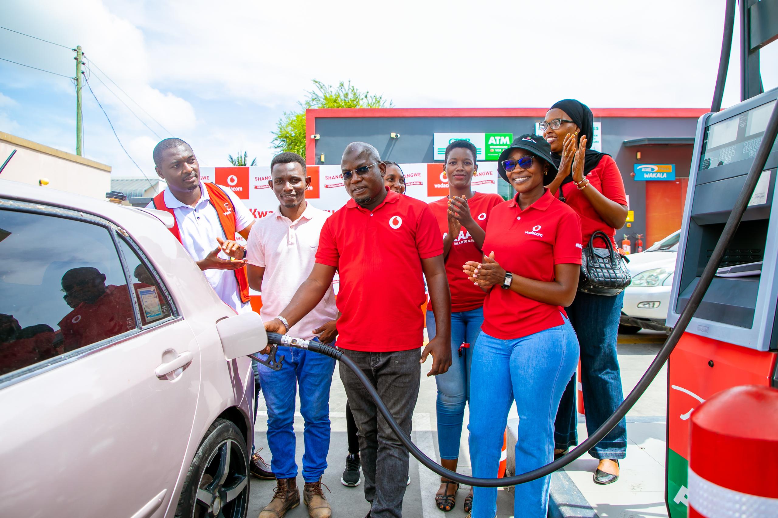 Vodacom Tanzania Plc Pwani Region Sales Manager, Suleiman Amri, refuels Ramadhan Kalafya’s car with complimentary fuel in Dar es Salaam, marking the finale of their holiday campaign aimed at delighting customers.