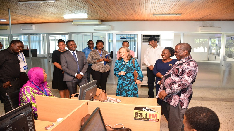 The British High Commissioner to Tanzania, Marianne Young (in blue-and-black dress), shares a light moment with members of The Guardian Limited (TGL) management and other staff while being shown around the publishing firm’s Newsroom. 