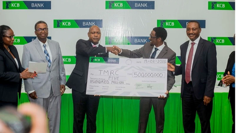 Anael Mshana (2nd R), representative of KCB Bank Board Chairman, hands over a dummy cheque to Board Chairman of Tanzania Mortgage Refinancing Company (TMRC), Theobald Sabi, following KCB Bank’s investment of 500m/- in the company.