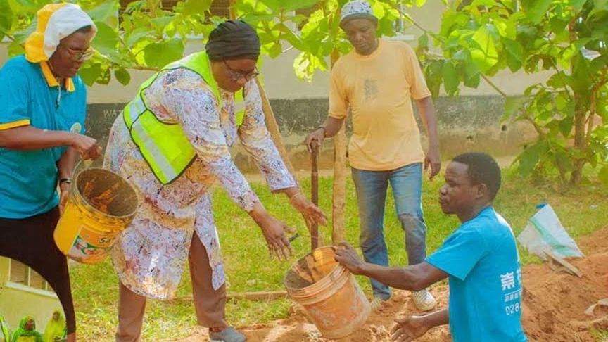 Mstahiki Meya wa Manispaa ya Mtwara-Mikindani, Shadida Ndile (wa katikati ), akishirikiana na wakazi wa Kata ya Chuno, kumwaga zege katika ujenzi wa msingi wa uzio. 