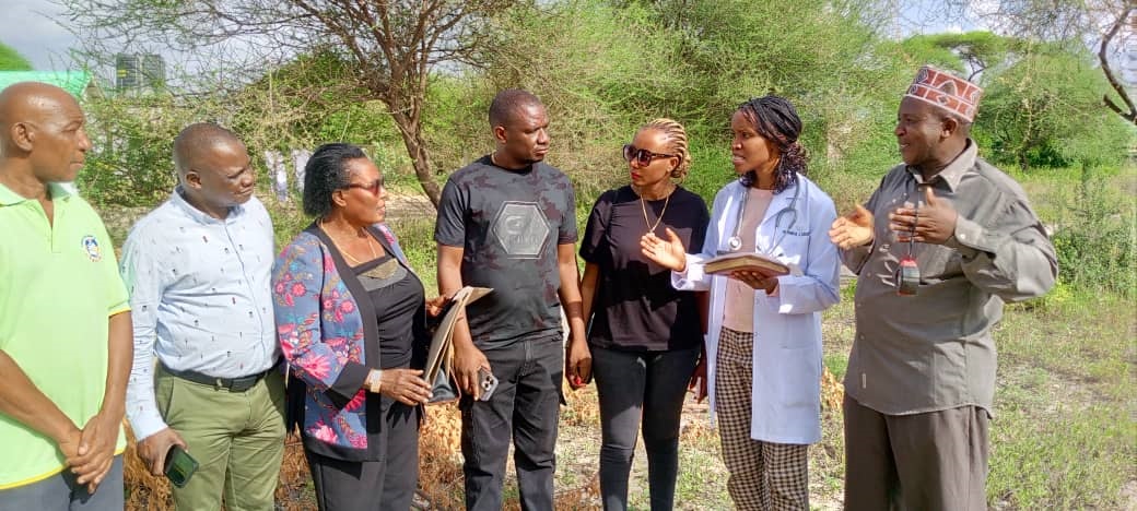 Dr Namnyaki Lukumay (2nd R), medical officer in-charge for Mirerani Health Centre in Simanjiro District, Manyara Region, explains to Joseph and Sporah Mwakipesile, plans for the construction of  women’s ward, children’s ward and consultation rooms.