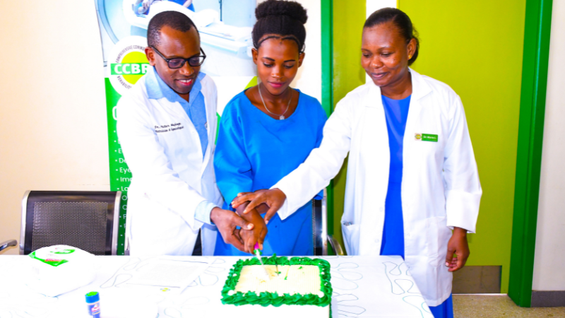 Bingwa wa Magonjwa ya Wanawake, Uzazi na Upasuaji wa Fistula katika Hospitali ya CCBRT Dk. Peter Majinge (kushoto), akikata keki pamoja na mmoja wa akinamama wanaoendelea na matibabu ya fistula hospitalini hapo, ikiwa ni sehemu ya maadhimisho