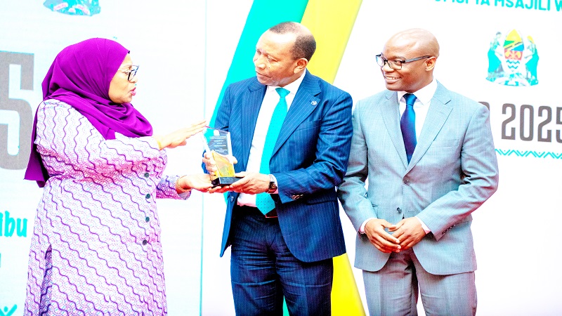 President Samia Suluhu Hassan has a quick word with Airtel Tanzania Board chairman Eliud Sanga (C) and Airtel Tanzania managing director Charles Kamoto when presenting a trophy in connection with the firm’s 73.9bn/- dividend payment to the government.