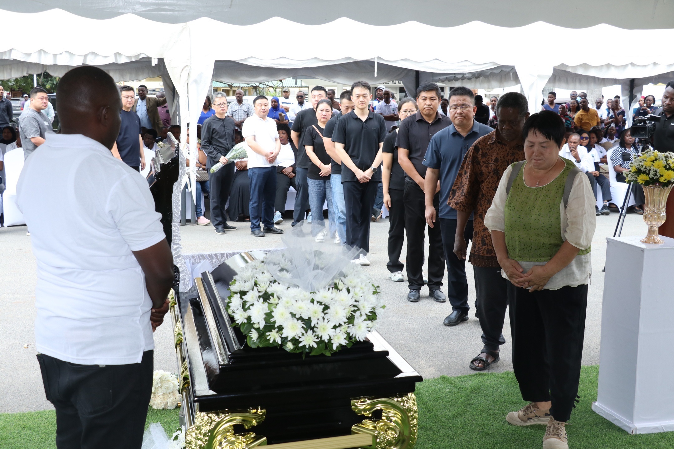 Relatives, members of the Muhimbili National Hospital community and other mourners pay their respects in Dar es Salaam on Friday to Dr Zhang Junqiao.The Chinese national, died last week while attempting to rescue a person from drowning in the Indian Ocean