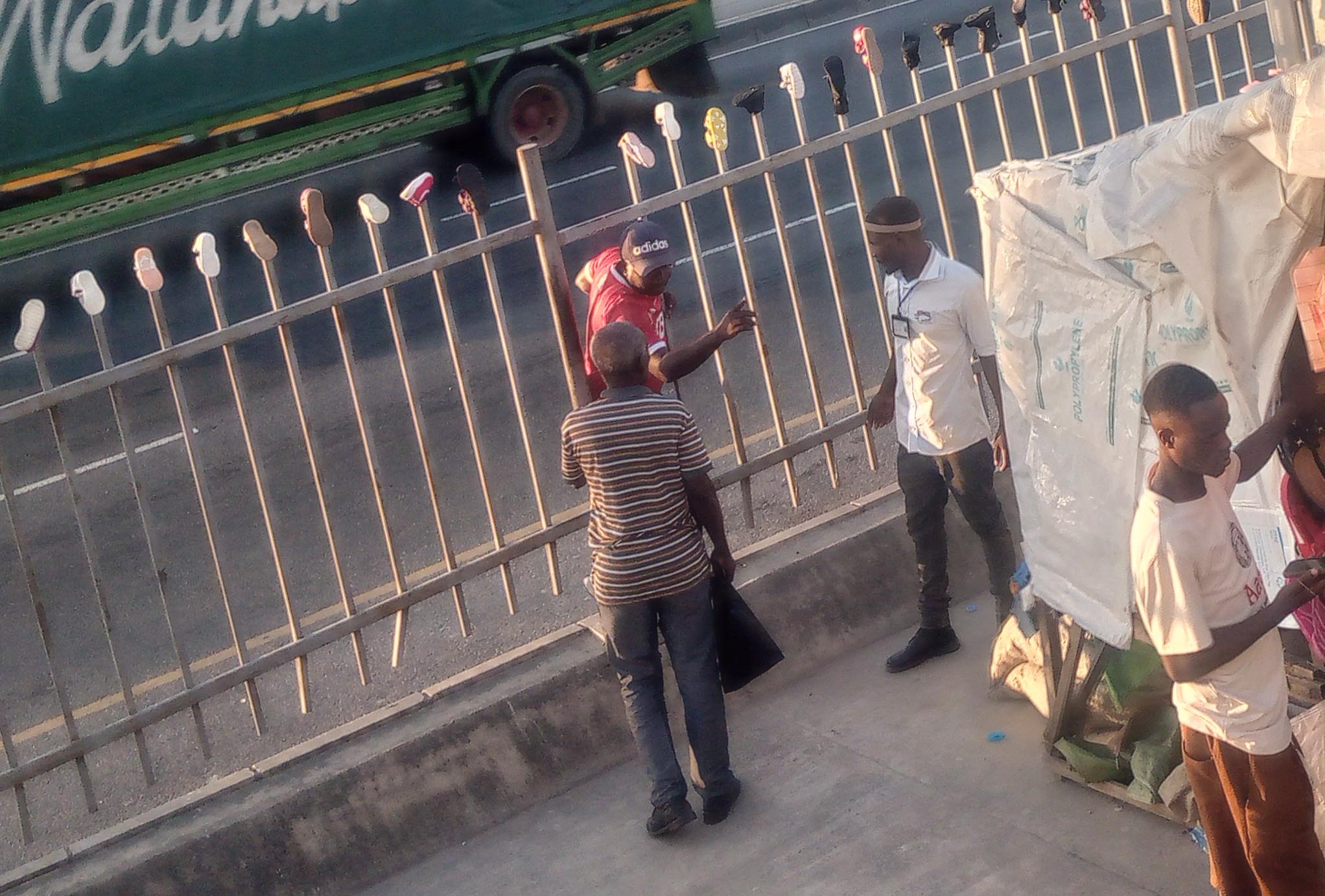  A pedestrian ostensibly in a hurry sneaks through a fence separating lanes at a Mbezi Luis section of Dar es Salaam’s Morogoro Road yesterday. 